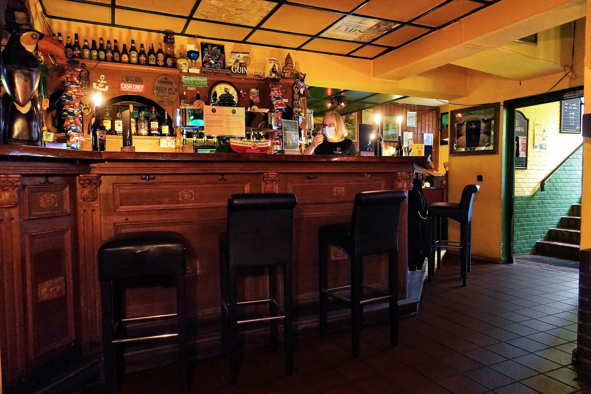 Bancone di un bar con sgabelli e macchina da caffè professionale a vista