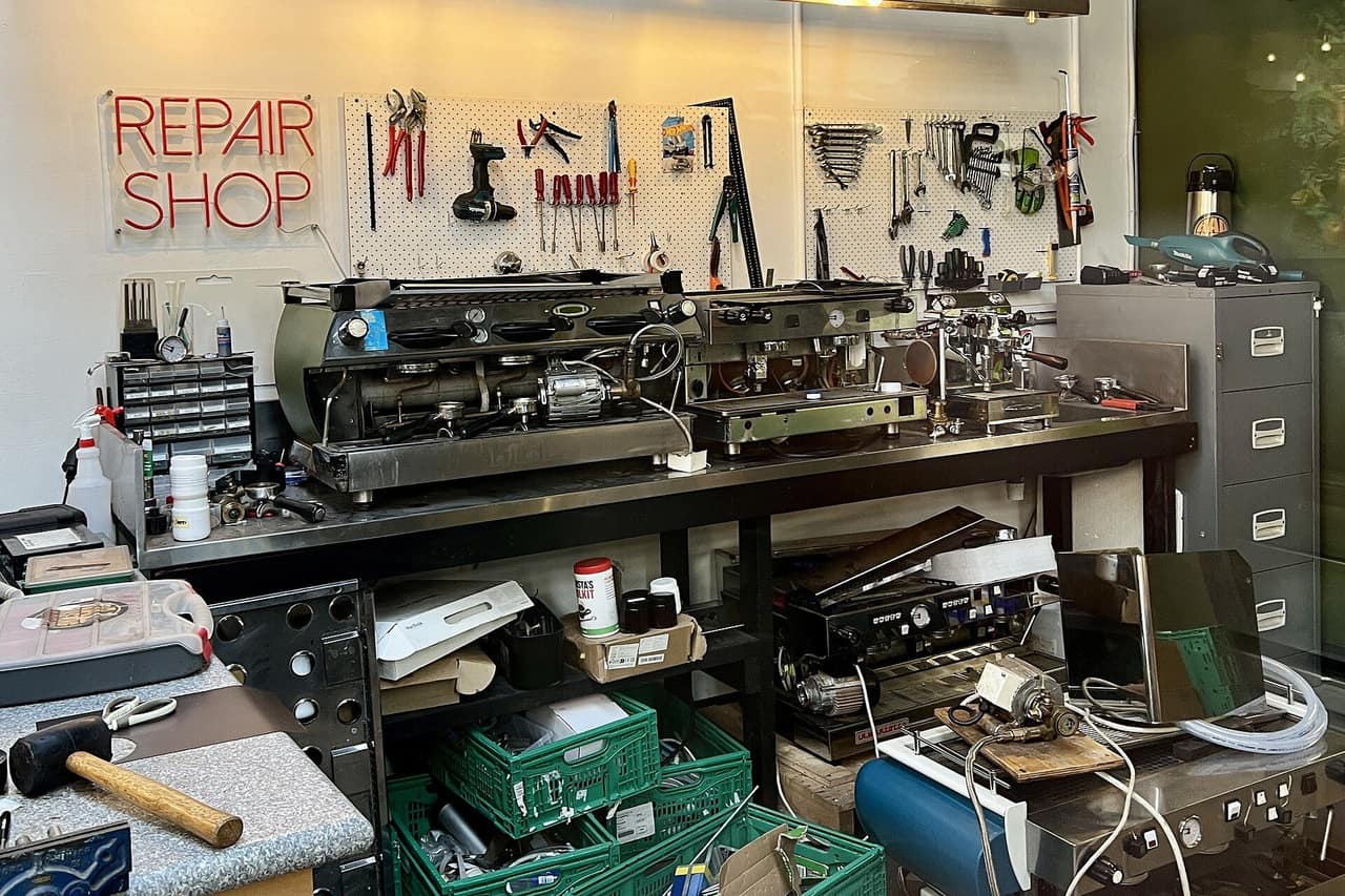 Officina di riparazione con macchine da caffè professionali e attrezzi