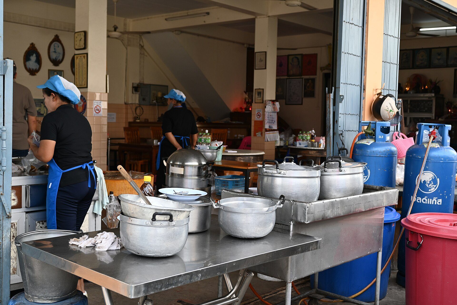 Cucina professionale in servizio con attrezzature in acciaio inox e pentole sul fuoco